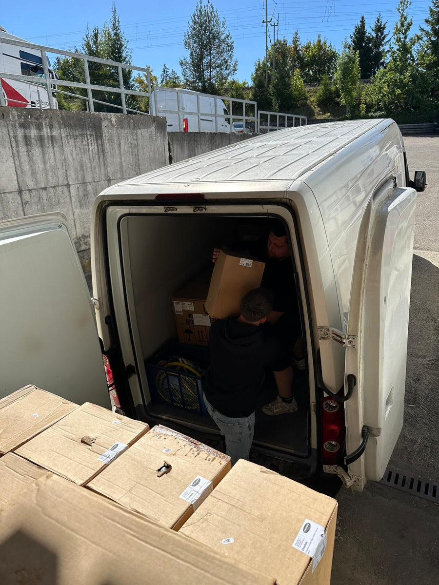 Moventum-Team beim sorgfältigen Einladen von Umzugskartons in den Transporter
